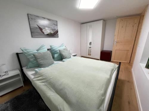ein Schlafzimmer mit einem großen weißen Bett mit blauen Kissen in der Unterkunft Schöne Ferienwohnung mit Jacuzzi in Hinterzarten in Hinterzarten