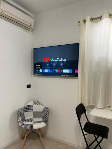 a room with a chair and a television on the wall at Hotel Iacone in Chieti