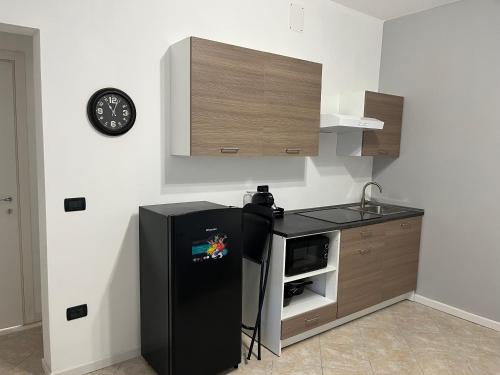 a kitchen with a black refrigerator and a sink at Hotel Iacone in Chieti