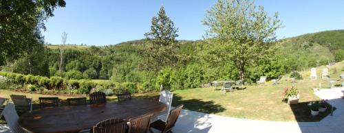a wooden table and chairs in a garden at Chambres d'hotes La Combette in Le Bleymard
