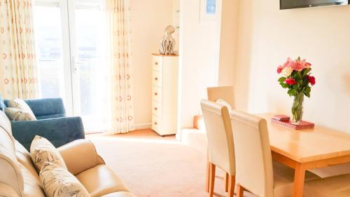 a living room with a table and a couch at Sandy Bay Apartment, St Ives Bay, Hayle in Hayle