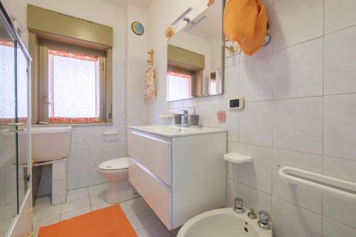 Baño blanco con aseo y lavamanos en Happy Home, en Taormina