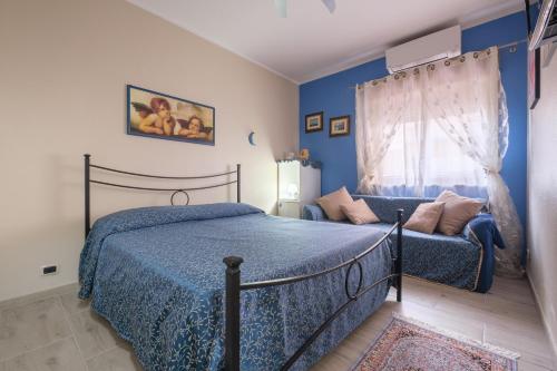 1 dormitorio con paredes azules, 1 cama y 1 sofá en Happy Home, en Taormina