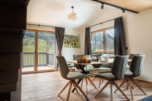a dining room with a table and chairs and a balcony at Alte Bildhauerei in Aurach bei Kitzbuhel