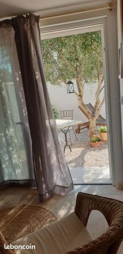 une porte donnant sur une terrasse avec une chaise et une fenêtre. dans l'établissement chambre indépendante avec jardin privatif, à La Londe-les-Maures