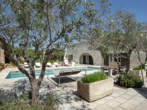 una casa con una piscina con un árbol en Masseria Bernardini Art Resort, en Nardò