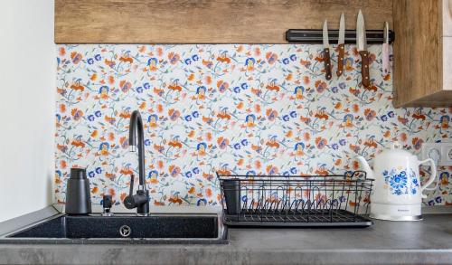a kitchen sink with a floral wallpaper on the wall at 1bdr flat close to the center in Stara Zagora