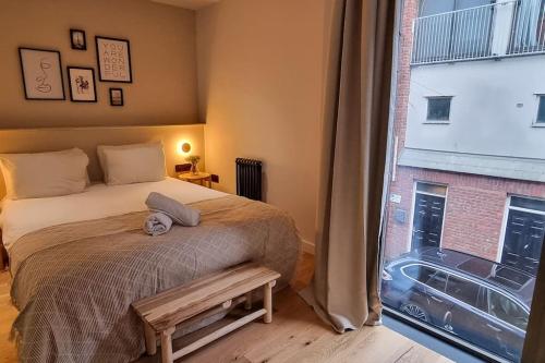 um quarto com uma cama e uma grande janela em Stunning Luxury Townhouse in Centre of Manchester em Manchester