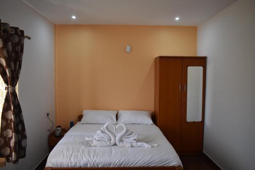 a bedroom with a bed with towels on it at DIAMOND HILL VIEW in Ketti