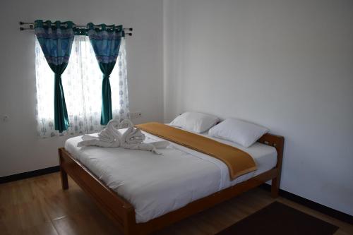 a bedroom with a bed and a window with curtains at DIAMOND HILL VIEW in Ketti