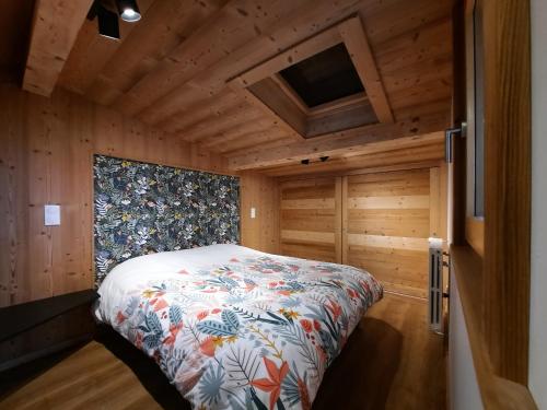 een slaapkamer met een bed in een houten kamer bij Appartement Les 3 cols Morzine, 2 pièces, 2 personnes in Morzine