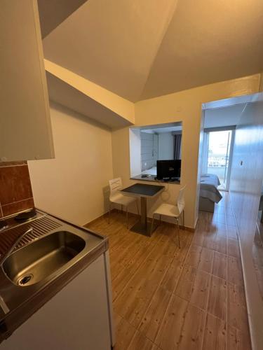 Il comprend une cuisine et un salon avec un évier et une table. dans l'établissement Apartments Villa Simoni, à Split