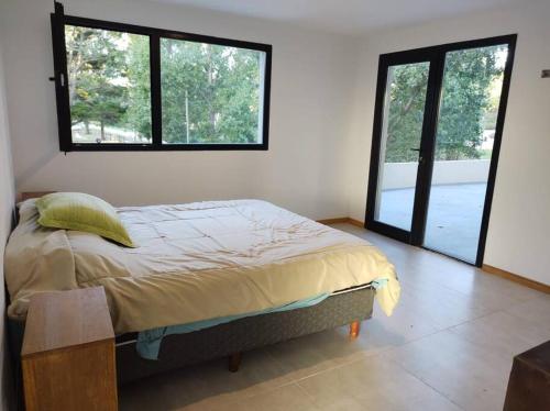 1 dormitorio con 1 cama y 2 ventanas grandes en Duplex Caleta en Mar de Cobo