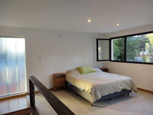 1 dormitorio con cama y ventana grande en Duplex Caleta en Mar de Cobo
