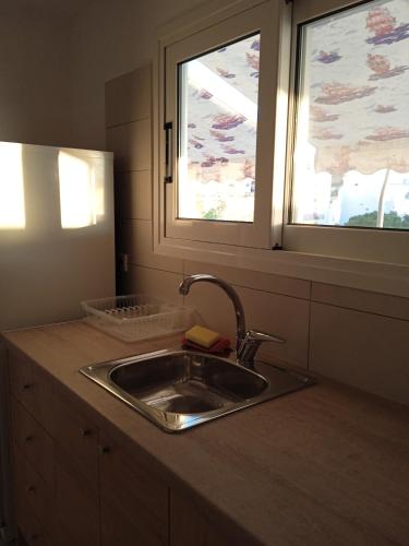 a kitchen counter with a sink and a window at Sky Loft in Loutraki