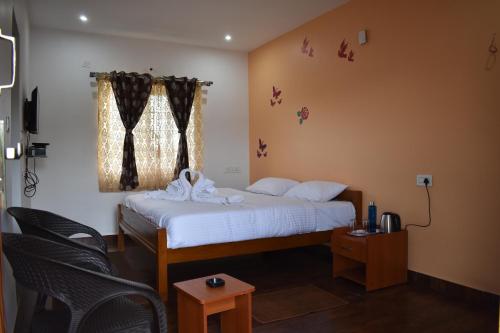 a bedroom with a bed with white sheets and a window at DIAMOND HILL VIEW in Ketti
