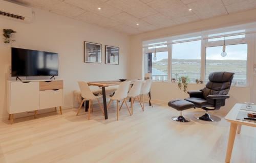 a living room with a dining room table and chairs at Unique Boathouse - Central - Kajak - Fitness in Strendur