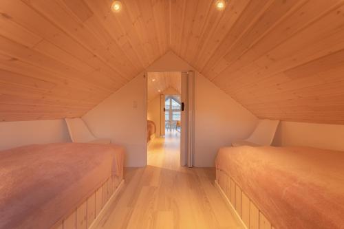 two beds in a room with wooden ceilings at Unique Boathouse - Central - Kajak - Fitness in Strendur