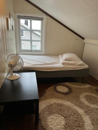 a small bedroom with a bed and a window at Familievennlig leiligheten leies ut på Sørlandet. in Vennesla