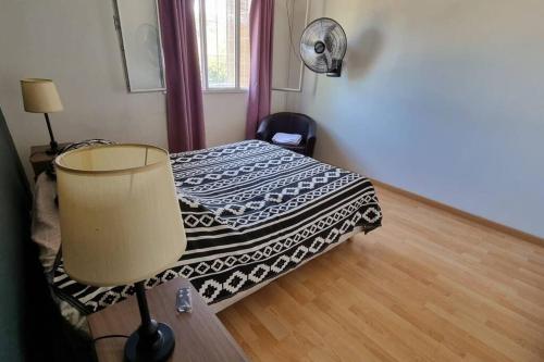 a bedroom with a bed and a table with a lamp at Departamento en increíble ubicación in Mendoza