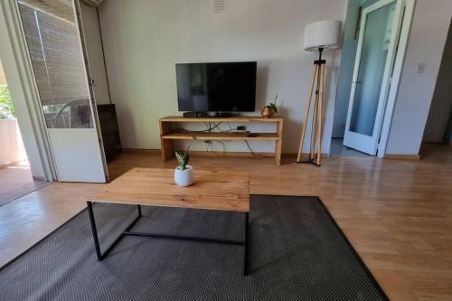 a living room with a table and a flat screen tv at Departamento en increíble ubicación in Mendoza
