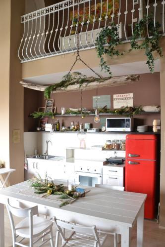a kitchen with a white table and a red refrigerator at La Combriccola in Santarcangelo di Romagna