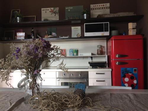 a kitchen with a red refrigerator and a vase of flowers at La Combriccola in Santarcangelo di Romagna