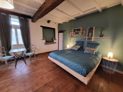 1 dormitorio con 1 cama, mesa y sillas en La Boriette du Rougier, en Montlaur