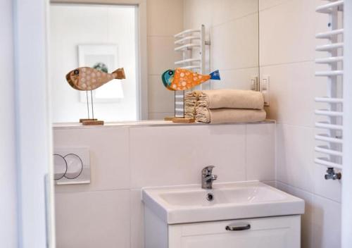 un baño con lavabo y espejo en Holiday Bay, en Władysławowo