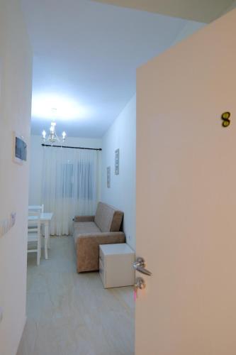 a living room with a couch and a table at Sunny Holiday in Sarandë