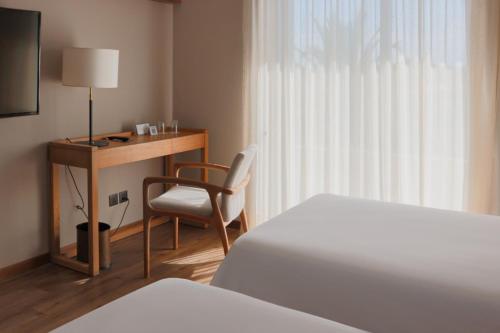 a hotel room with a desk and a bed and a chair at Cottage Carrasco in Montevideo