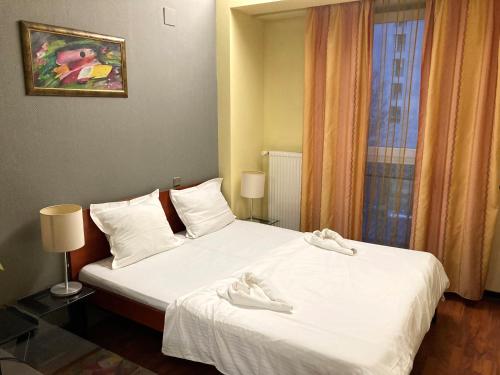 Un dormitorio con una cama con zapatos blancos. en Tania-Frankfurt Hotel, en Bucarest