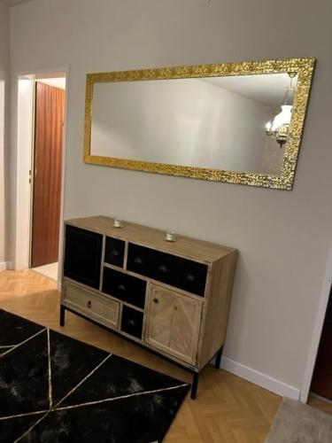 a wooden dresser in a living room with a mirror at Pension COLUMBIA inkl. Frühstück im Zentraum in Bad Gleichenberg