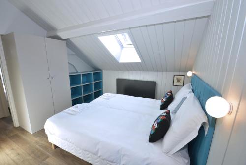 - une chambre avec un lit blanc et une lucarne dans l'établissement Appartement Bellevue - centre ville, à Chamonix-Mont-Blanc