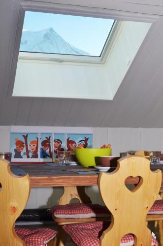 une lucarne dans une chambre avec une table et des chaises dans l'établissement Appartement Bellevue - centre ville, à Chamonix-Mont-Blanc