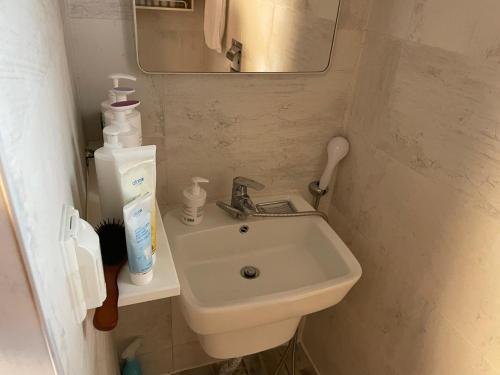 a small bathroom with a sink and a mirror at Chaehyodang Hanok Stay in Seoul