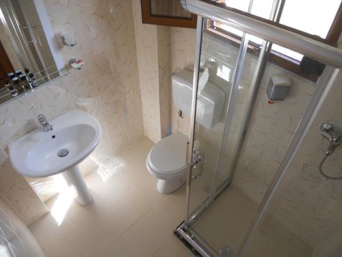 a bathroom with a toilet and a sink and a shower at Onorato Hotel in Vlorë