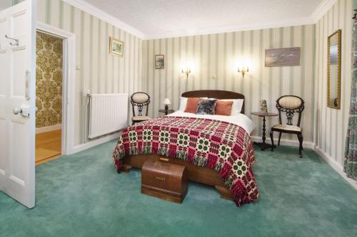 a bedroom with a bed with a red and black blanket at Ty Bledrws - family retreat near the Cardigan Bay coast in Llangybi