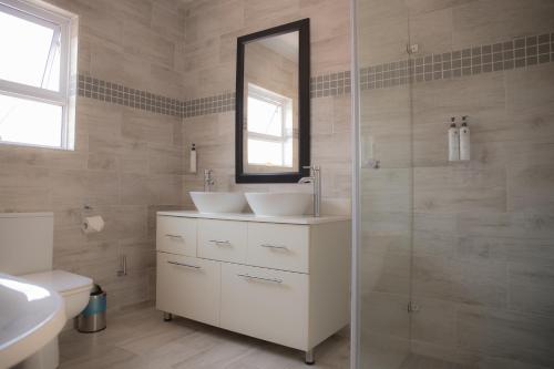 a bathroom with two sinks and a mirror at Gletwyn Boutique Guesthouse in Harare