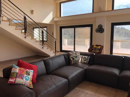 a living room with a black leather couch with pillows at B&B Zia Nì in Peschici