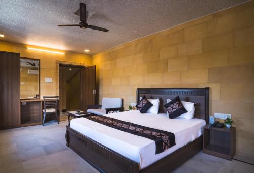 a bedroom with a large bed with a ceiling fan at Hotel Akashdeep - Located City Centre in Jaisalmer