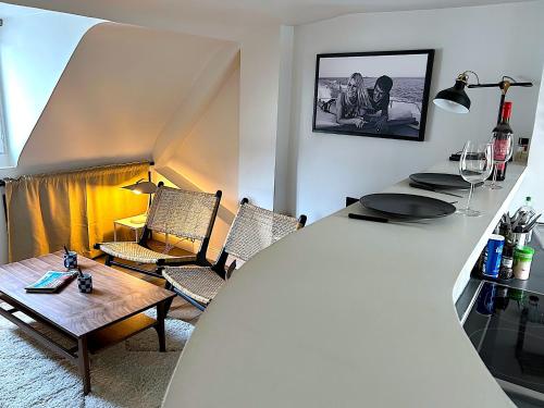 un salon avec une table, des chaises et un canapé dans l'établissement Le Penthouse Picardie, à Paris