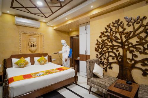 a bedroom with a bed with a tree mural on the wall at Hotel Akashdeep - Located City Centre in Jaisalmer