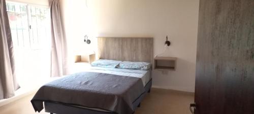 1 dormitorio con 1 cama en una habitación con ventana en Vista andes II en Luján de Cuyo