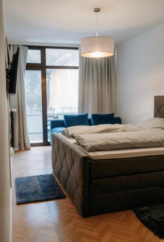 a bedroom with a large bed and a couch at Pension COLUMBIA inkl. Frühstück im Zentraum in Bad Gleichenberg