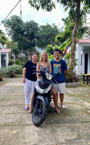 a group of people standing next to a motor scooter at Eden House & Coffee Con Dao in Con Dao