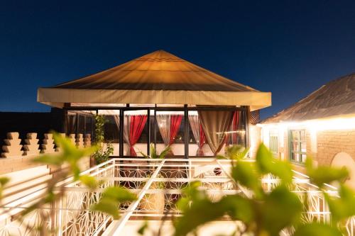a gazebo with red curtains in front of a building at Dar Salam Palm - Guest Choice Award 2024 in Marrakech