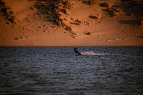 a person kite surfing in the water at sunset at Caravan Dakhla by Our Habitas in Dakhla