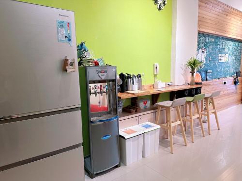 una cucina con frigorifero e bancone con sedie di Happy Fat B&B 寵物友善 a Città di Taitung