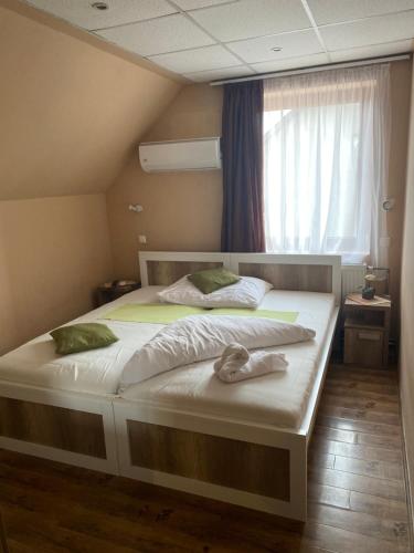 a bedroom with two beds and a window at Abszolút Hotel és Panzió in Nyírbátor